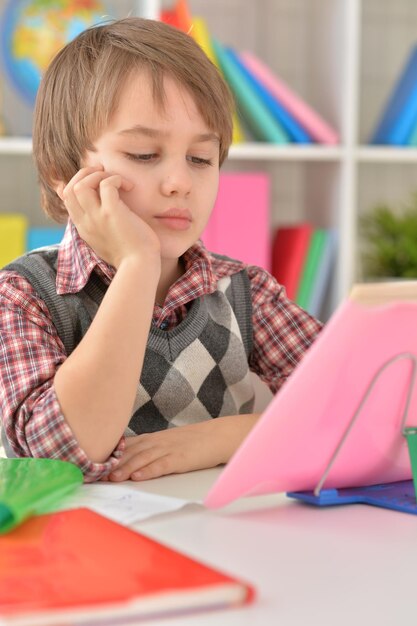 Portret skoncentrowanego małego chłopca odrabiającego pracę domową