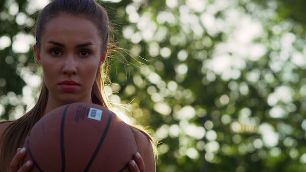 Portret skoncentrowanej kobiety grającej w koszykówkę streetball na świeżym powietrzu