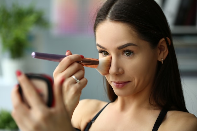 Zdjęcie portret śliczna brunetka robi makeup