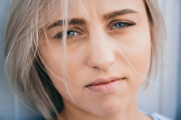 Zdjęcie portret śliczna dziewczyna z białą krótką fryzurą. jej włosy zakrywają pół twarzy. ona nie może się doczekać.