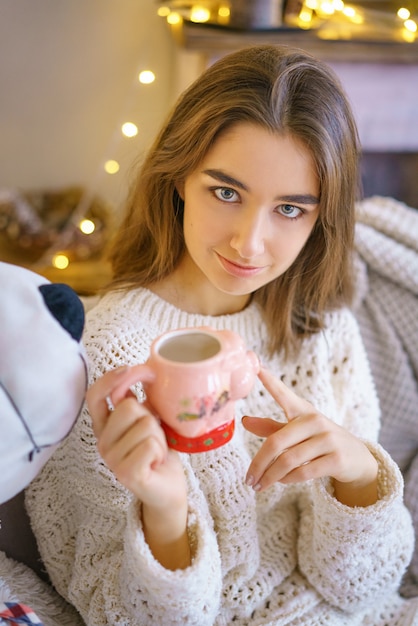 Portret śliczna dziewczyna z miękkiej zabawki niedźwiedziem i girlandami z bokeh