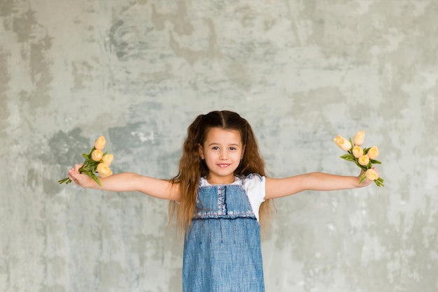 Portret śliczna mała dziewczynka z kwiatami. Wiosenny portret. Dzień Matki.