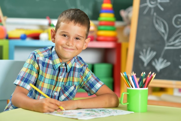 Portret ślicznego Małego Chłopca Rysującego Ołówkiem W Klasie