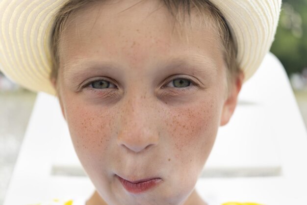 Portret ślicznego Pięknego Chłopca W Kapeluszu Z Piegami Zbliżenie Chłopca O Poważnym I Smutnym Spojrzeniu I