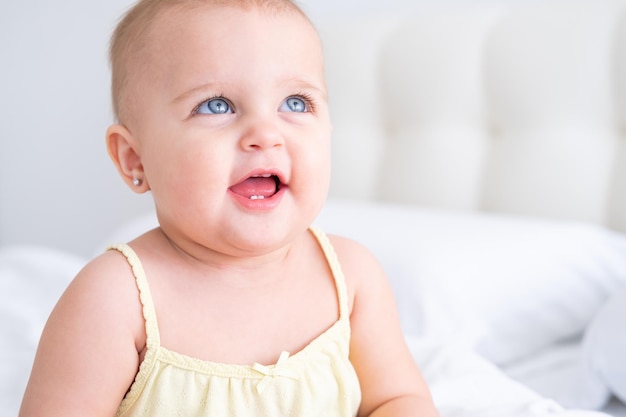 portret ślicznej dziewczynki uśmiechającej się z pierwszymi zębami mlecznymi. Zdrowe nowo narodzone dziecko