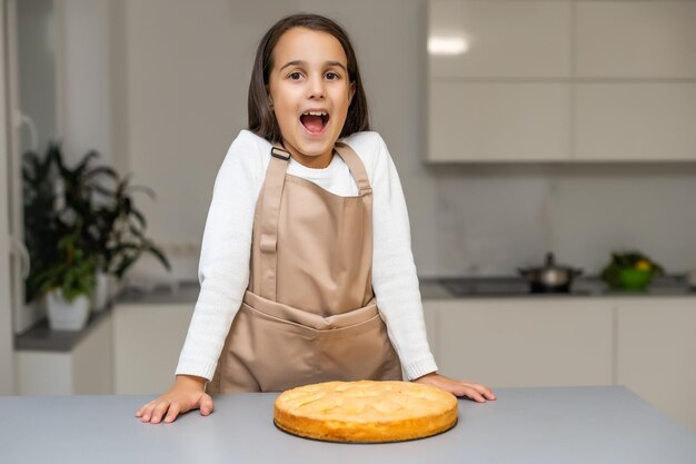 Portret ślicznej małej dziewczynki trzymającej domowe ciasto