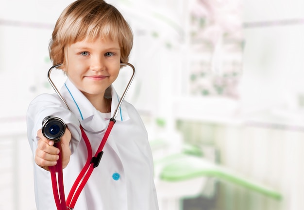Zdjęcie portret ślicznej małej dziewczynki trzymającej w ręku stetoskop grający w lekarza