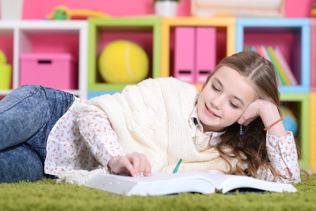 Portret ślicznej szczęśliwej dziewczyny studiującej w domu