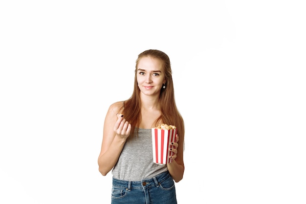 Portret śmiejącej się kobiety w ubranie, trzymając pudełko popcornu. Piękna kobieta z uśmiechem.