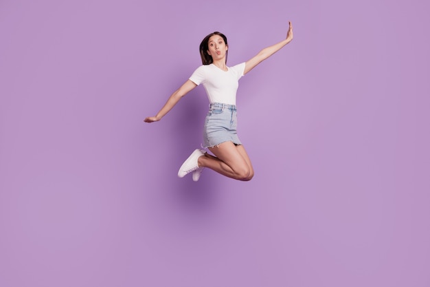 Portret śmiesznej funky pozytywnej pani skaczącej latać cieszyć się beztroskim weekendem na fioletowym tle