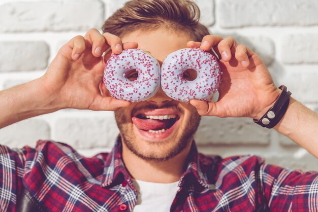 Portret śmieszni Faceta Mienia Pączki Na Oczach.