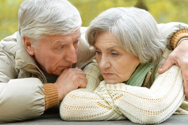 Zdjęcie portret smutnej pary starszych w jesiennym parku