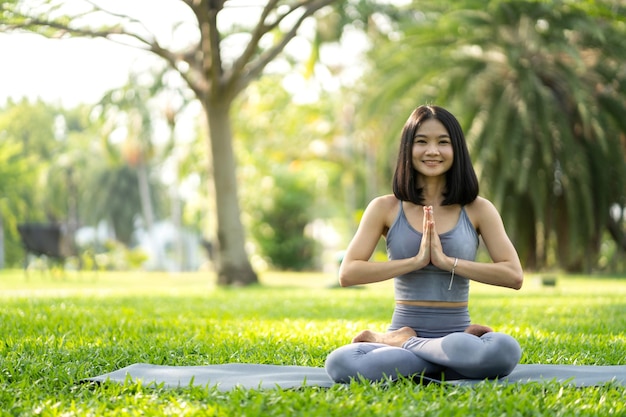 Portret sport azjatyckie piękno ciała szczupła kobieta w sportowej siedzi relaks i dziewczyna ćwiczy jogę i robi ćwiczenia fitness w parku w domuKoncepcja dietyFitness i zdrowe