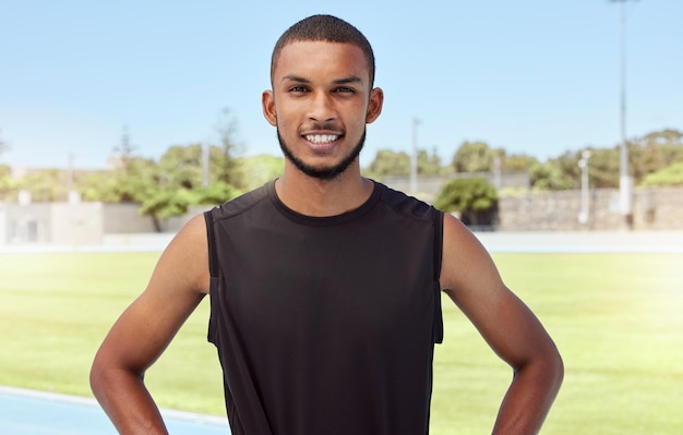 Portret sprawnego aktywnego młodego sportowca stojącego samotnie przed pójściem na bieg na boisku Latynoski mężczyzna wyglądający pewnie i uśmiechnięty na zewnątrz, przygotowujący się do codziennych rutynowych ćwiczeń na zewnątrz