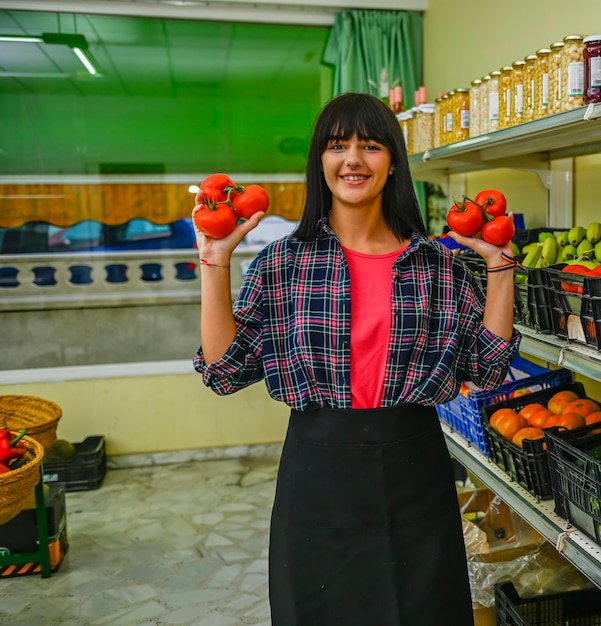 Portret sprzedawcy w sklepie z owocami, przedstawiający czerwone pomidory