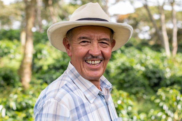 Portret starego kolumbijskiego chłopa w kapeluszu i patrzącego w kamerę z szerokim uśmiechem