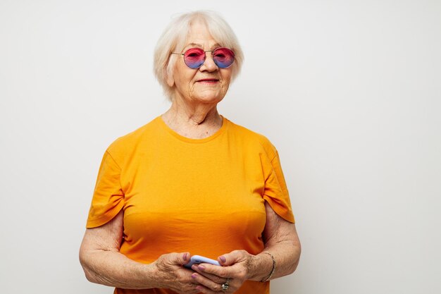 Portret starej przyjaznej kobiety szczęśliwego stylu życia w żółtych koszulkach na białym tle