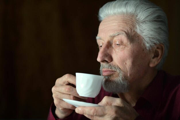 Portret starszego mężczyzny pijącego w domu