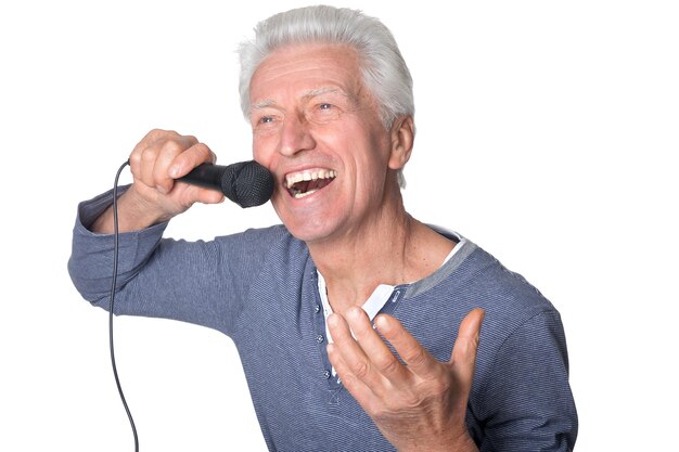 Portret starszego mężczyzny śpiewającego karaoke na białym tle