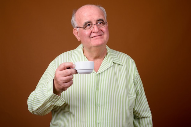 Portret starszego mężczyzny z nadwagą, trzymając filiżankę kawy