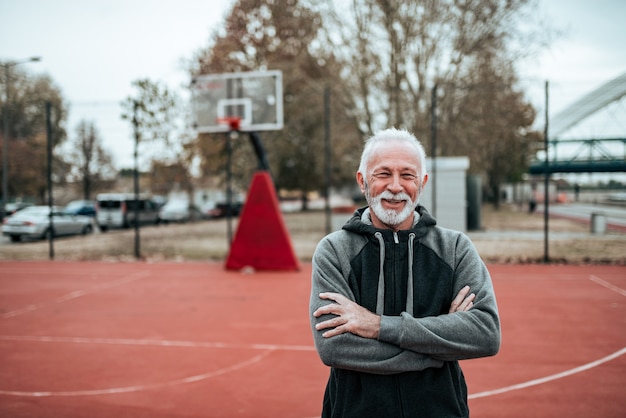 Portret starszego sportowca w odkrytym stadionie.