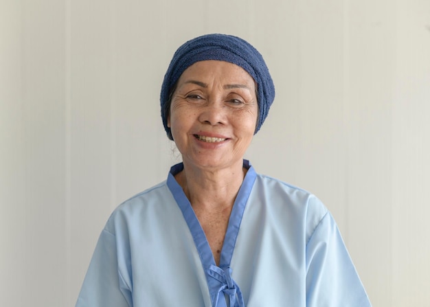 Portret starszej kobiety chorej na raka noszącej chustę na głowie w szpitalu