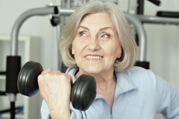 Portret starszej kobiety ćwiczącej w siłowni