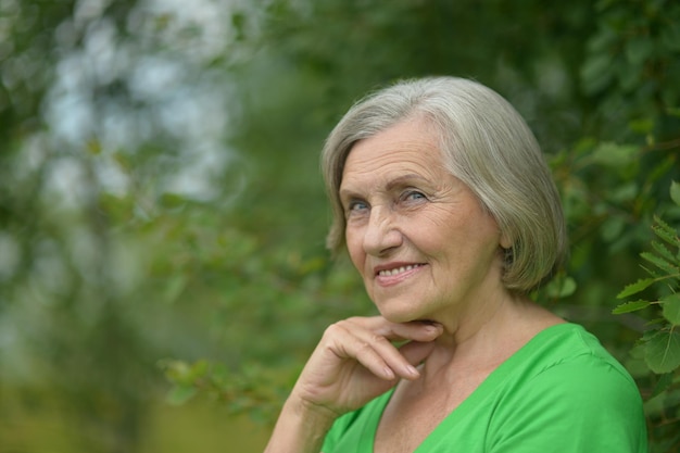 Portret starszej kobiety w letnim parku