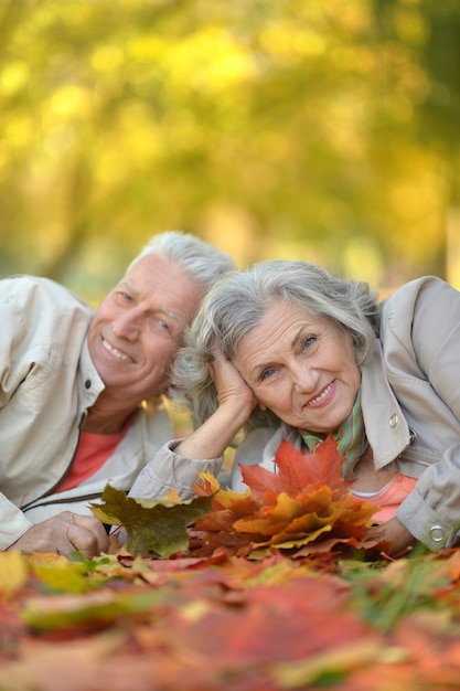 Portret starszej pary odpoczywającej w jesiennym parku