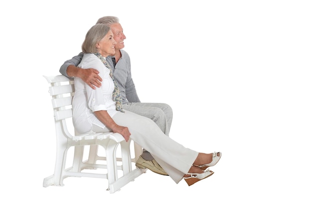 Portret starszej pary siedzącej na ławce izolowane na białym tle pełnej długości