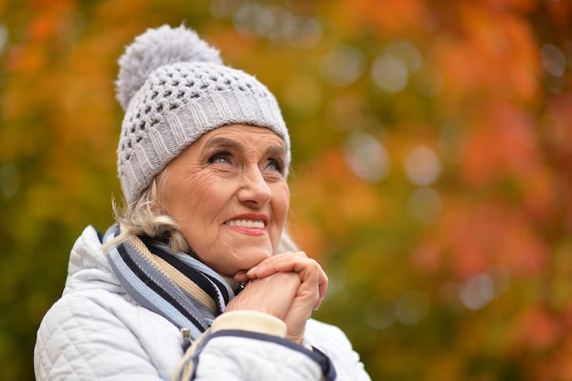 Portret starszej pięknej kobiety w jesiennym parku