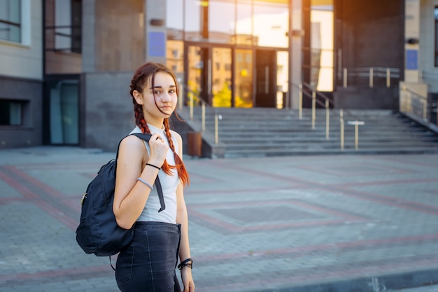 Portret studenta, dziewczyna z plecakiem idąc na studia z ulicy