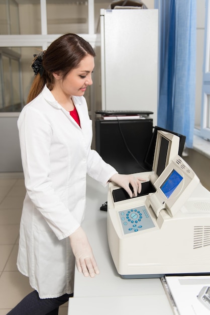 Portret studenta rasy kaukaskiej w laboratorium chemicznym, uśmiechający się i patrzący w kamerę