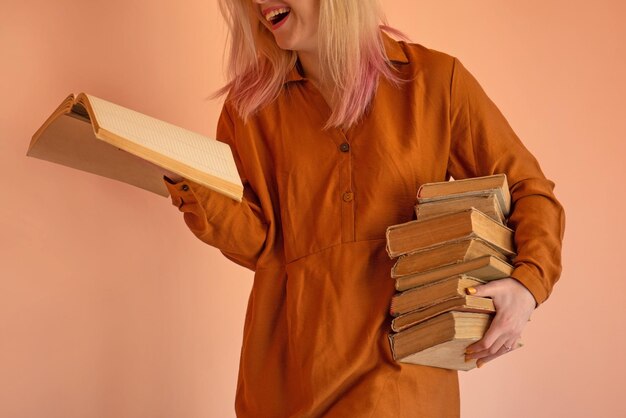Portret studenta trzyma książkę Uśmiechnięta dziewczyna ubrana w zwykłe ubranie czyta książkę