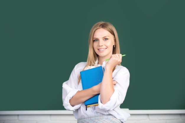 Portret studentki studiującej w szkole lub na uniwersytecie kreatywna młoda uśmiechnięta fe...