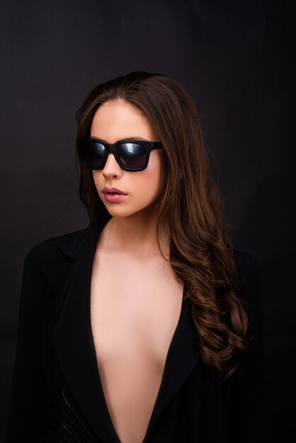 Portret studio sztuki mody pięknej eleganckiej młodej kobiety w okularach przeciwsłonecznych na czarno
