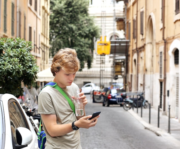 Portret stylu życia młodego mężczyzny relaksującego się Turysta patrzący na mapę używający smartfona
