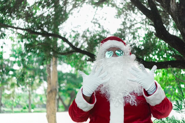Portret Świętego Mikołaja na świetle bokeh pod drzewemTajlandiaWysłane szczęście dla dzieciWesołych ŚwiątWitamy w zimie