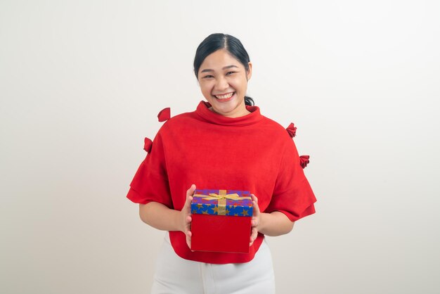 portret szczęśliwa Azjatycka kobieta ubrana w czerwoną koszulę z pudełkiem na rękę na świąteczny festiwal