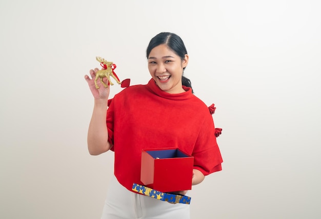 portret szczęśliwa Azjatycka kobieta ubrana w czerwoną koszulę z pudełkiem na rękę na świąteczny festiwal