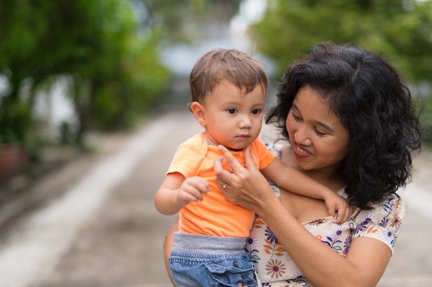 Portret szczęśliwa azjatycka matka i synek wieloetnicznego spajania razem na zewnątrz