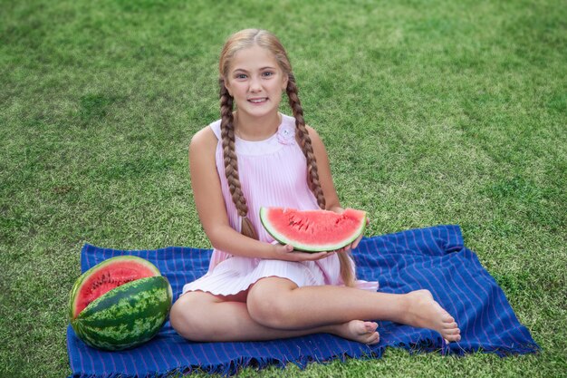 Portret szczęśliwa dziewczyna z arbuza enjoing letni dzień na świeżym powietrzu.