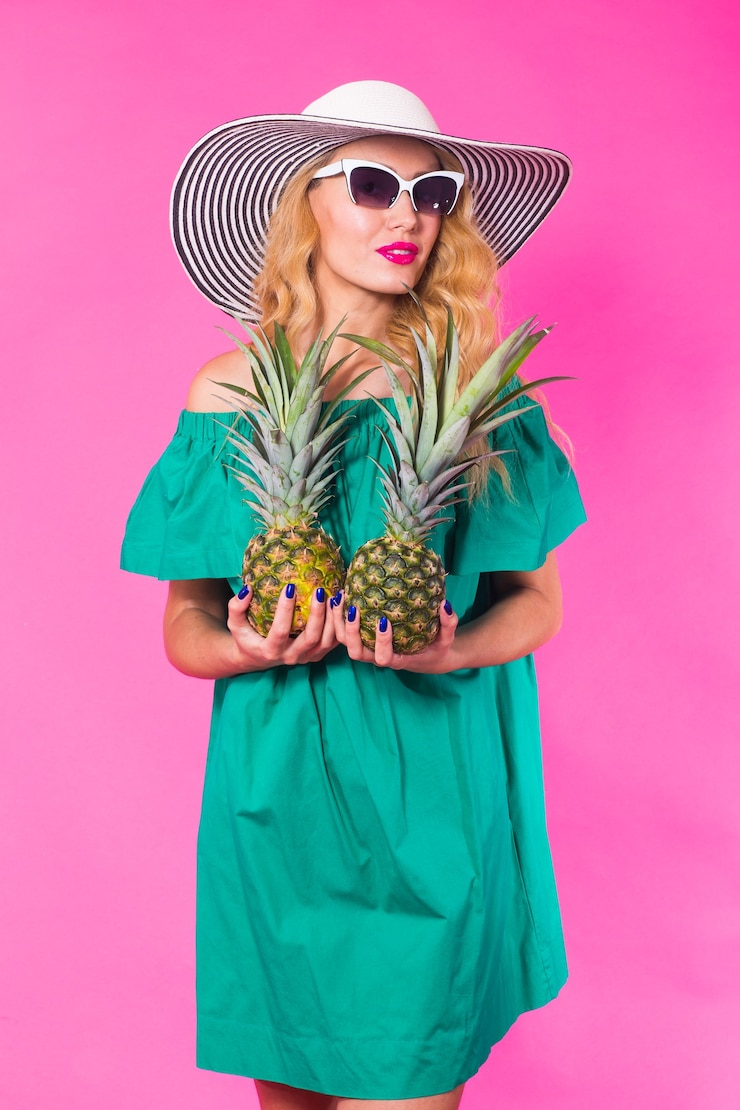 Zdjęcie portret szczęśliwa kobieta i ananas na różowym tle. lato, dieta i zdrowy tryb życia