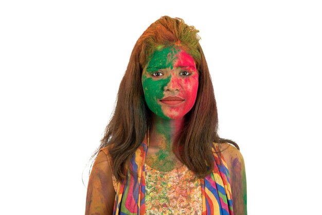 Portret szczęśliwa młoda dziewczyna z kolorową twarzą na festiwalu kolorów Holi na białym tle