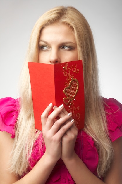 Portret szczęśliwa młoda kobieta trzyma valentine kartę