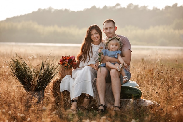 Portret szczęśliwa młoda rodzina spędza czas na naturze w letni dzień razem