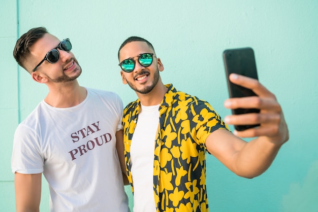 Portret szczęśliwa para gejów spędzać czas razem i robić selfie z telefonem komórkowym. Koncepcja lgbt i miłość.