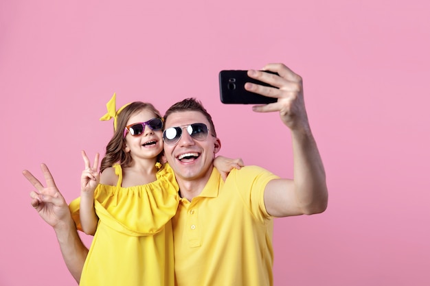 Portret szczęśliwa rodzina w żółtej odzieży z okularami przeciwsłonecznymi
