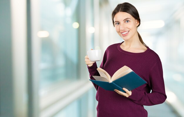 Portret szczęśliwa studencka kobieta z książkami w bibliotece