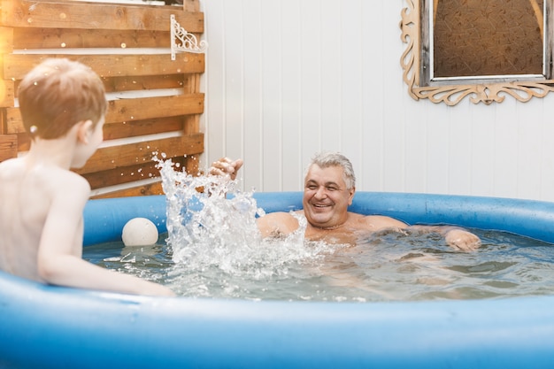 Portret Szczęśliwego Dziadka Z Wnukiem Bawiącym Się W Basenie